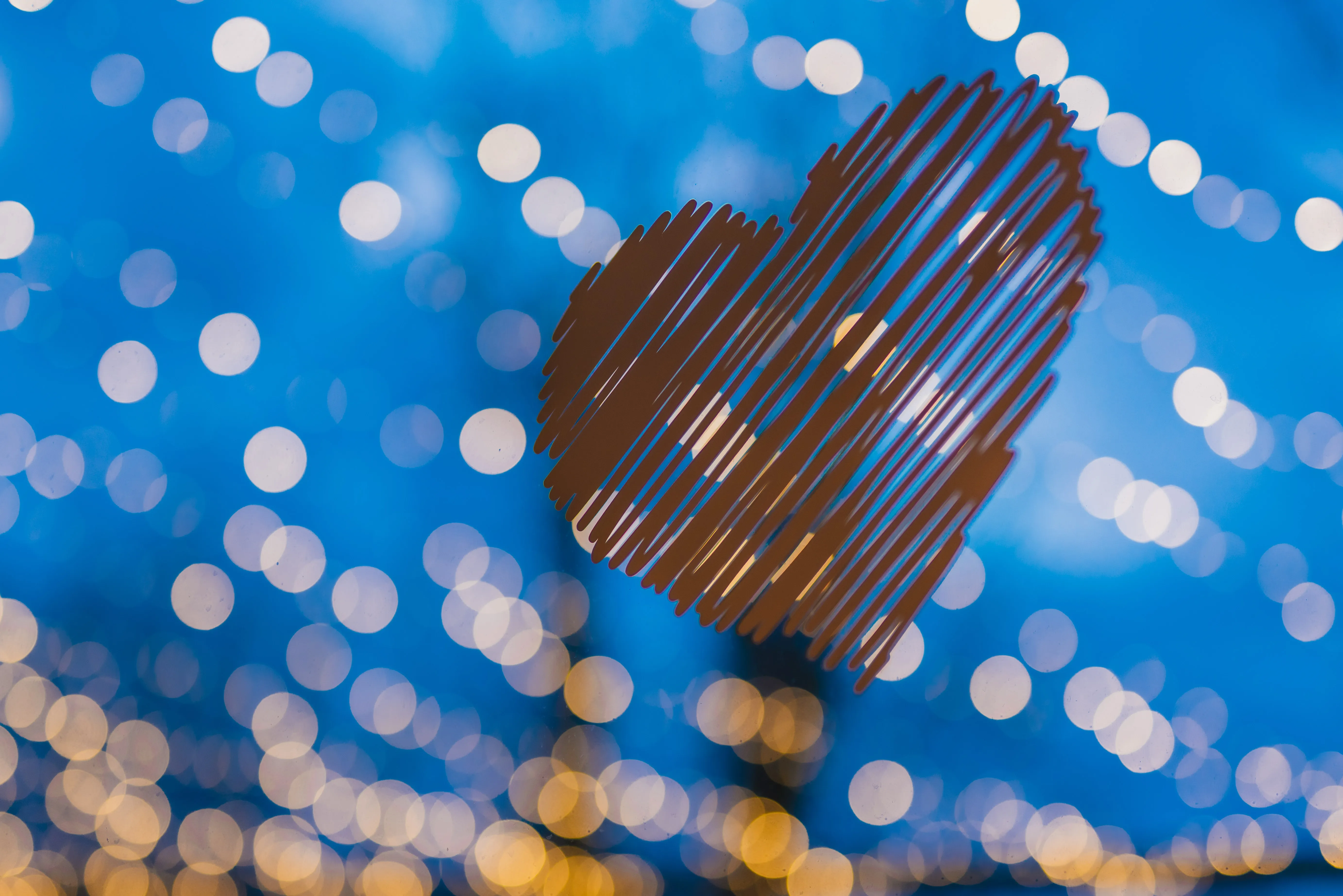 Herz-Dekoration vor blauem Abendhimmel mit Bokeh von Lichterketten auf der Terrasse