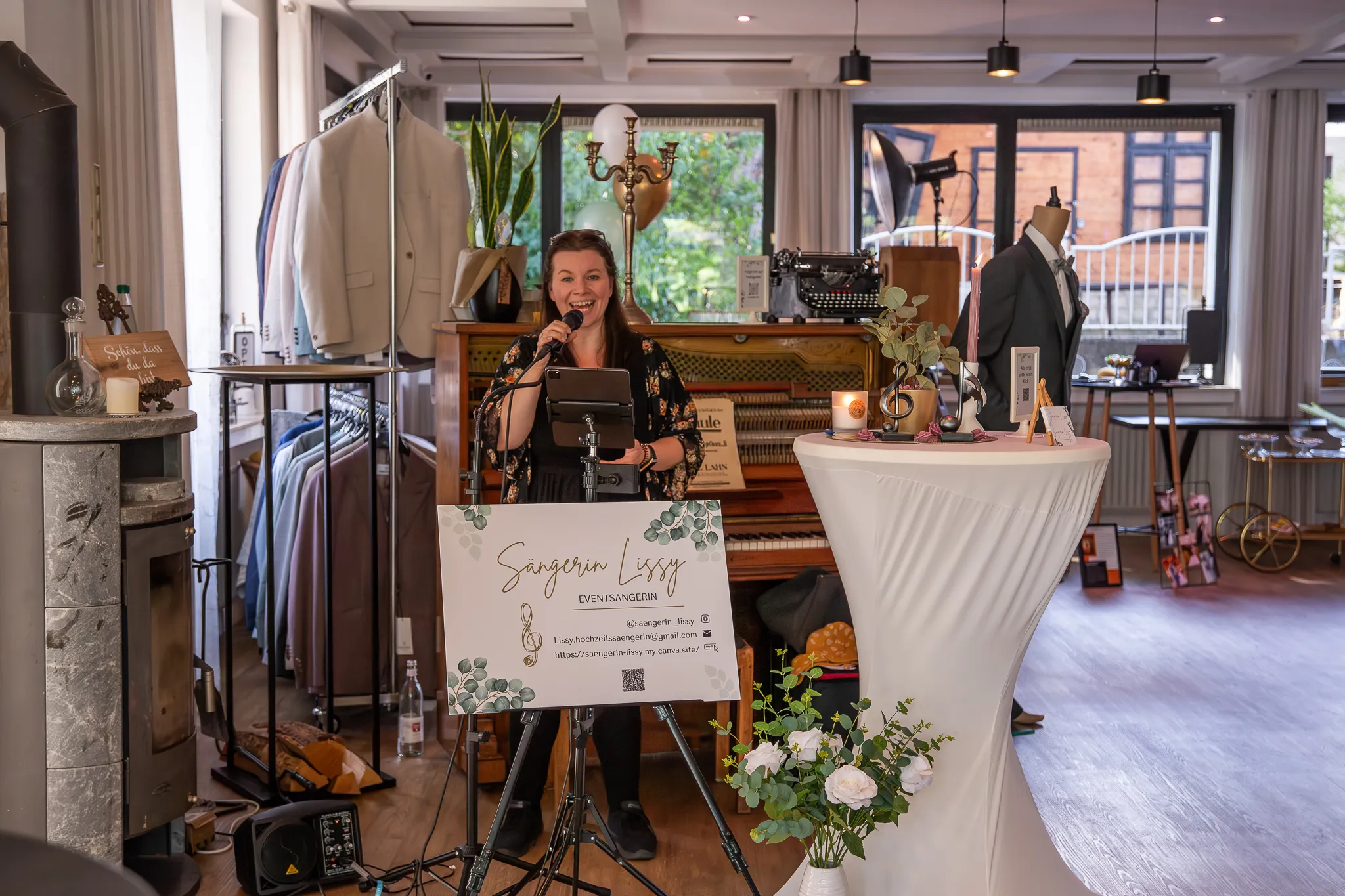 Sängerin mit Mikrofon performt vor einem alten Klavier bei einer Veranstaltung