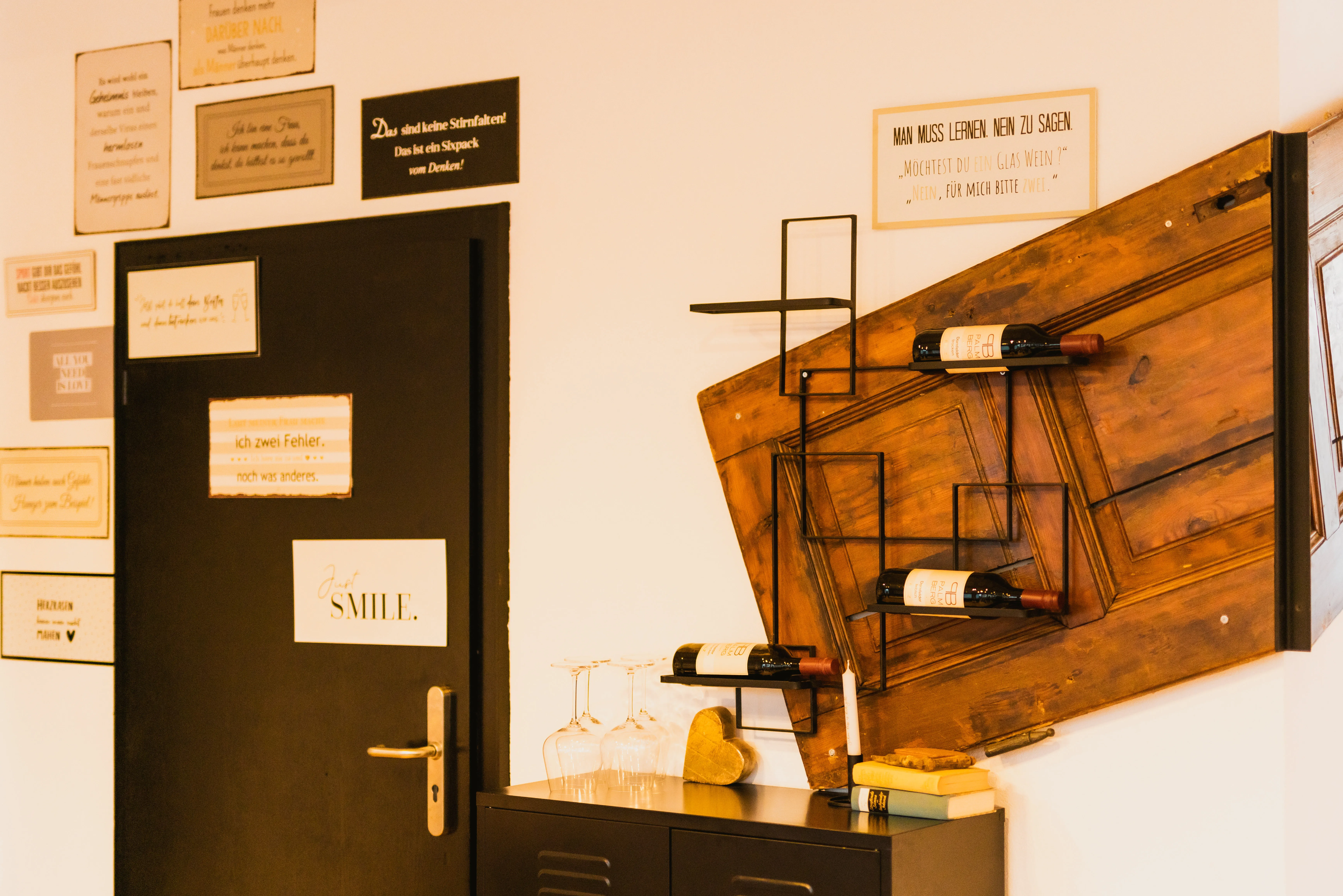 Antike Holztür als Wanddeko mit Weinregal und Spruchschildern im Vintage-Festsaal