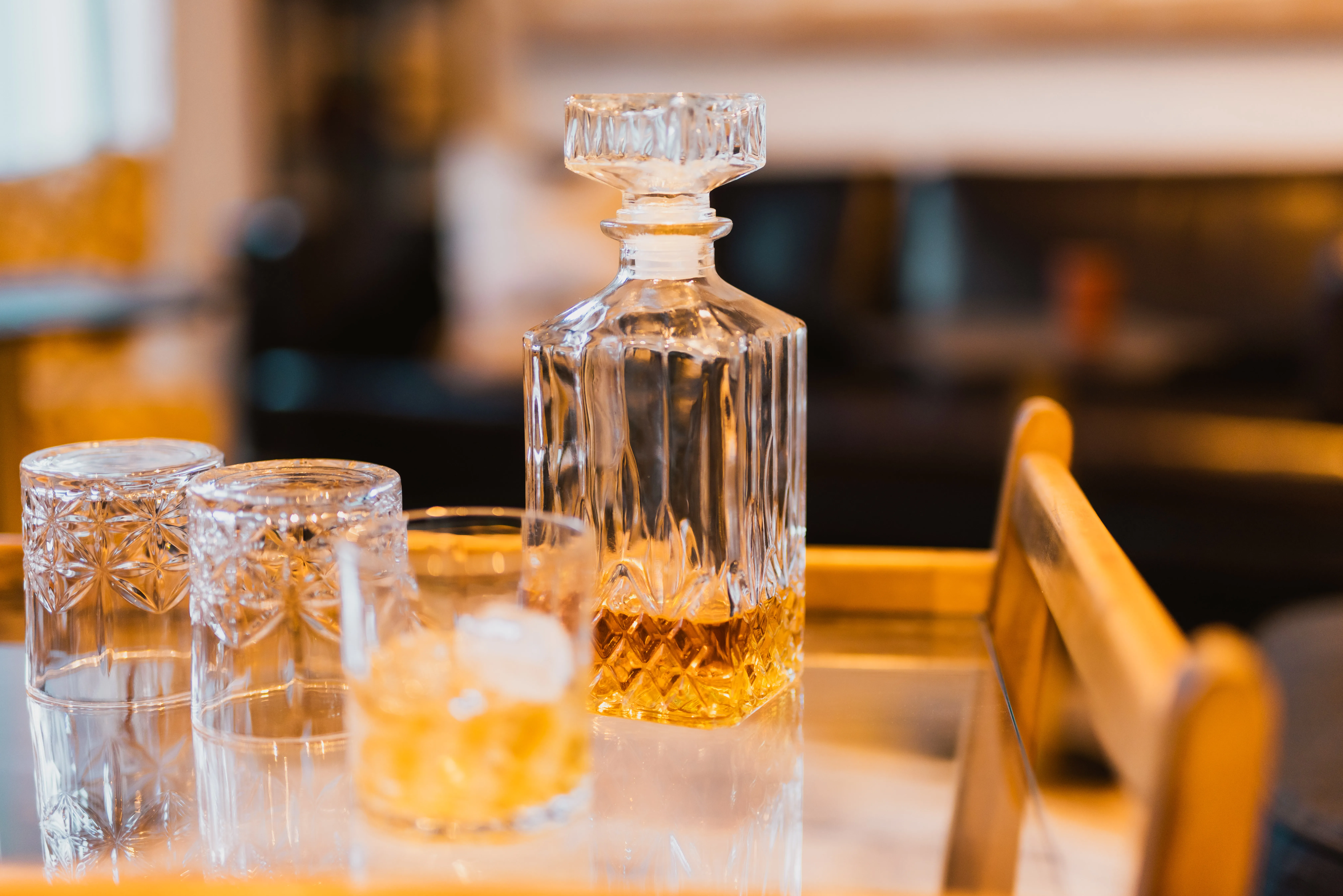 Kristallkaraffe mit Whisky und geschliffene Gläser auf einem Tablett